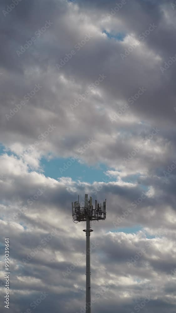 5g mobile network communication tower with cellular antenna transmitter and receiver, broadcasting 4g lte equipment, phone network station on sky with clouds background, vertical video footage 4k