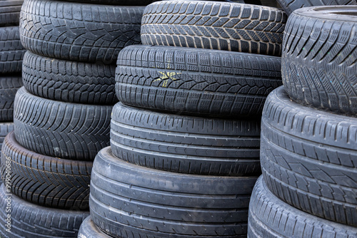 Obraz na płótnie Stack of old, worn and damaged tires lying in a landfill. Decreased road safety and environmental pollution from rubber waste w salonie