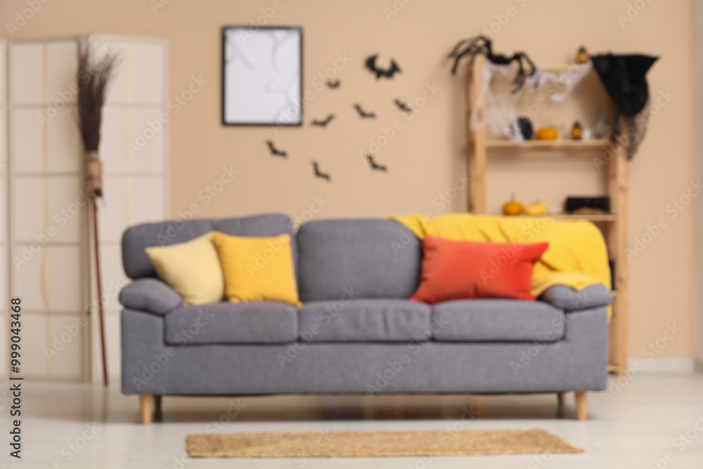 Obraz premium Interior of modern living room decorated for Halloween with sofa, shelving unit and folding screen
