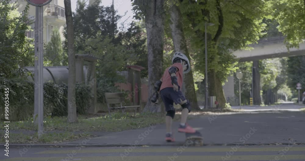 Boy skateboarding in a park, maintaining balance as he rides forward. The scene captures his focus and determination in an open, tree-lined path surrounded by nature