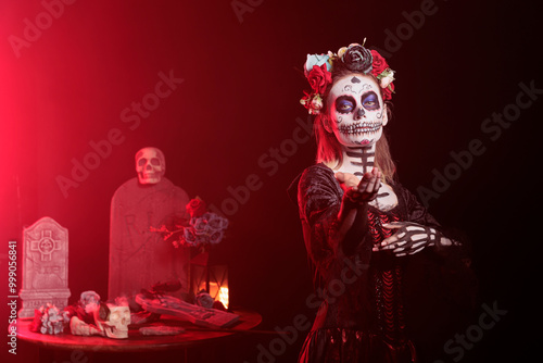 Tablou pe pânză Dark lady does enticing invitation hand gesture during Dia de los Muertos, preserving cultural traditions