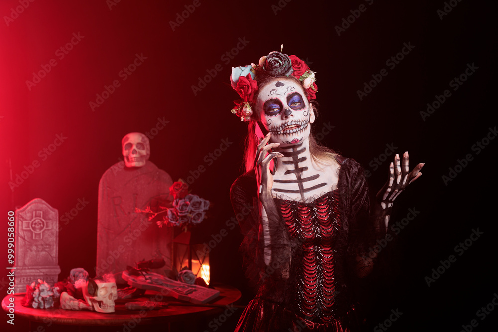 Fototapeta premium Portrait of woman in telephone call during Day of the Dead Mexican celebration honoring dead loved ones. Person talking on cellphone while doing ancient Aztec custom of celebrating ancestors