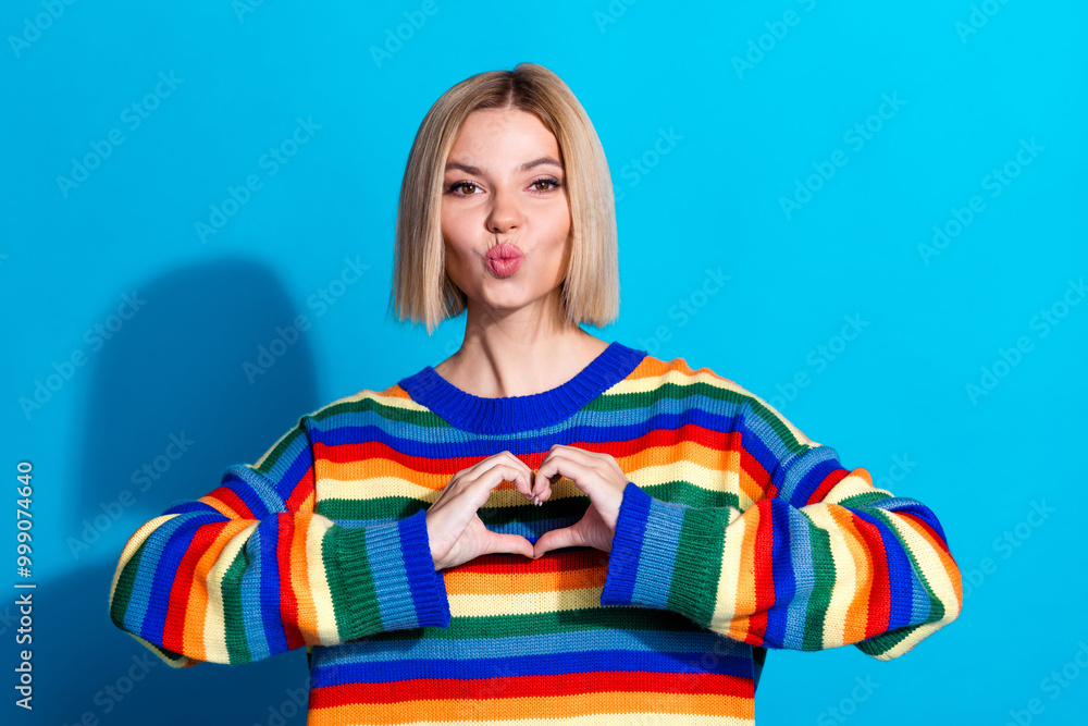 Photo of nice young woman kiss show heart symbol wear striped sweater isolated on blue color background