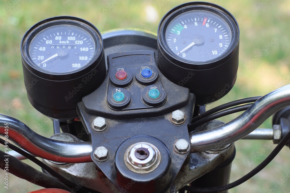 two black round plastic speedometers on the dashboard of an old motorcycle on a summer street two black round plastic speedometers on the dashboard of an old motorcycle on a summer street