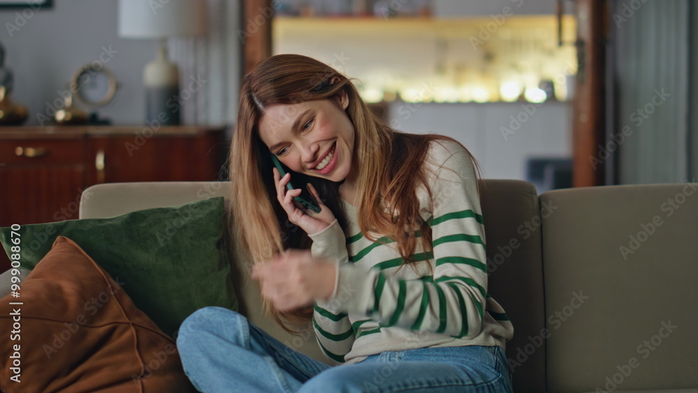 Obraz premium Joyful woman talking mobile phone relaxing at home couch. Smiling girl gossiping