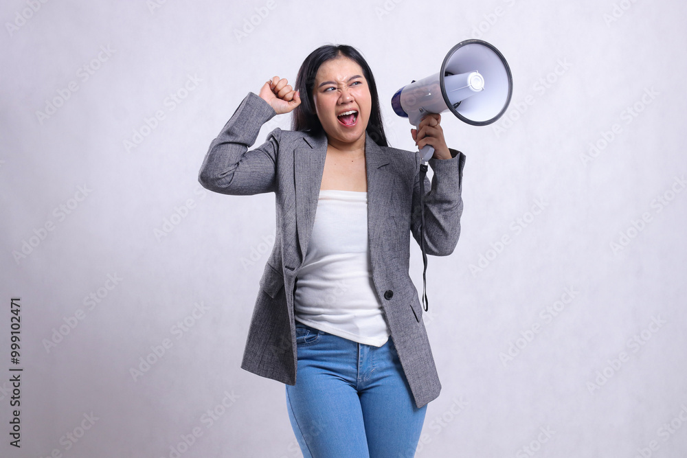Fototapeta premium beautiful adult ladies asia formal angry candid shouting hand holding megaphone loudspeaker and clenched fist up wearing grey suit isolated on white background. fashion concept, lifestyle, advertising