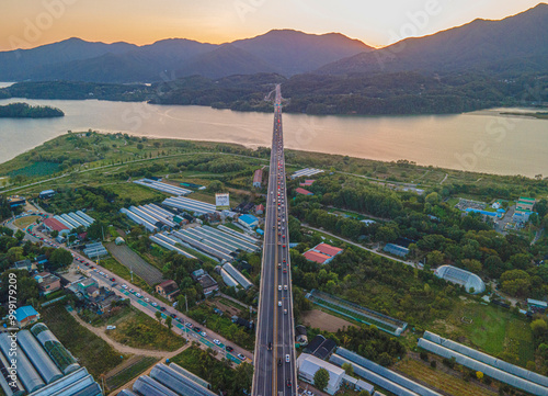 Dumulmeori, Yangpyeong-gun, Gyeonggi-do, South Korea - September 26, 2020: Aerial and sunset view of Shinyangsu Bridge on Bukhangang River and houses of village photo