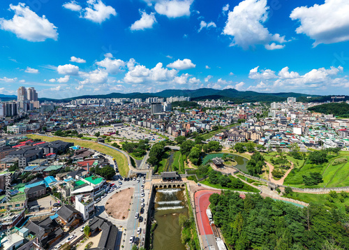 Suwon-si, Gyeonggi-do, South Korea - August 23, 2020: Aerial view of Suwoncheon Creek and Hwahongmun Gate of Suwon Hwaseong Fortress surrounded by houses photo