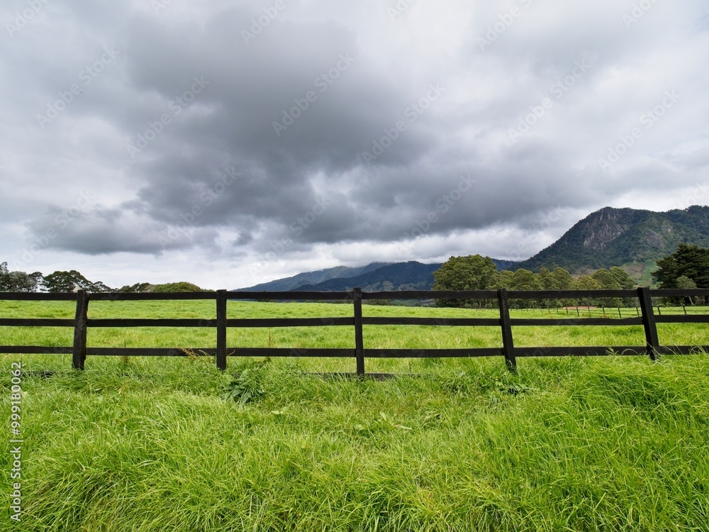 Mountains with a fence and pasture in the foreground Mountains with a fence and pasture in the foreground