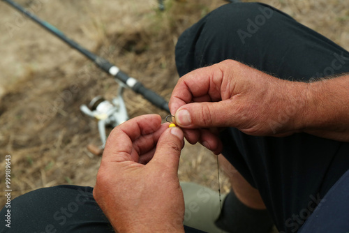 Senior fisherman holding fishing equipment outdoors, closeup