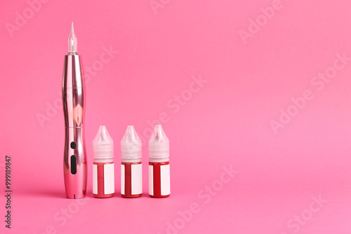 Permanent makeup machine and pigments on pink background. Space for text photo