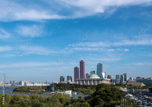 Yeouido, Yeongdeungpo-gu, Seoul, South Korea - October 5, 2020: Olympic boulevard and Seoul Marina on Han River against National Assembly and Park One financial district in the background