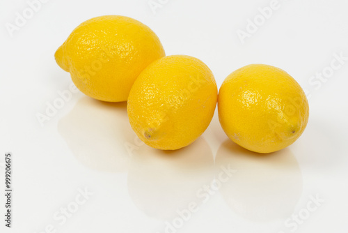 Three yellow lemons in a row on white background, South Korea