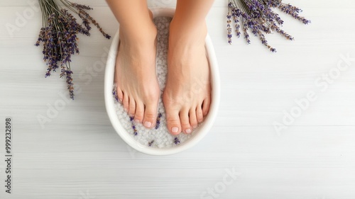 Feet in a detoxifying foot bath with Epsom salts and dried lavender, peaceful home spa scene