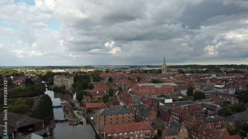 Drone video moving up showing Newark by Newark Town Lock. St Mary Cathedral and Newark Castle can be seen on this cloudy day as the building industrial and residential buildings. Drone video moving up showing Newark by Newark Town Lock. St Mary Cathedral and Newark Castle can be seen on this cloudy day as the building industrial and residential buildings.