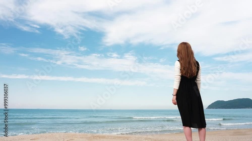 糸島の海。立っている女性。