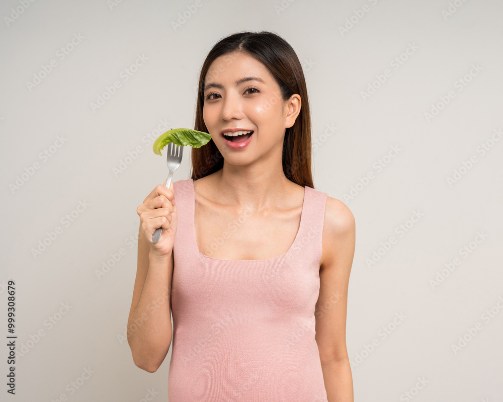 Happy Pregnant asian woman stroking touch belly motherhood eating fresh vegetable on isolated background. Family planning maternity and pregnancy with insurance for child health. Happy Pregnant asian woman stroking touch belly motherhood eating fresh vegetable on isolated background. Family planning maternity and pregnancy with insurance for child health.