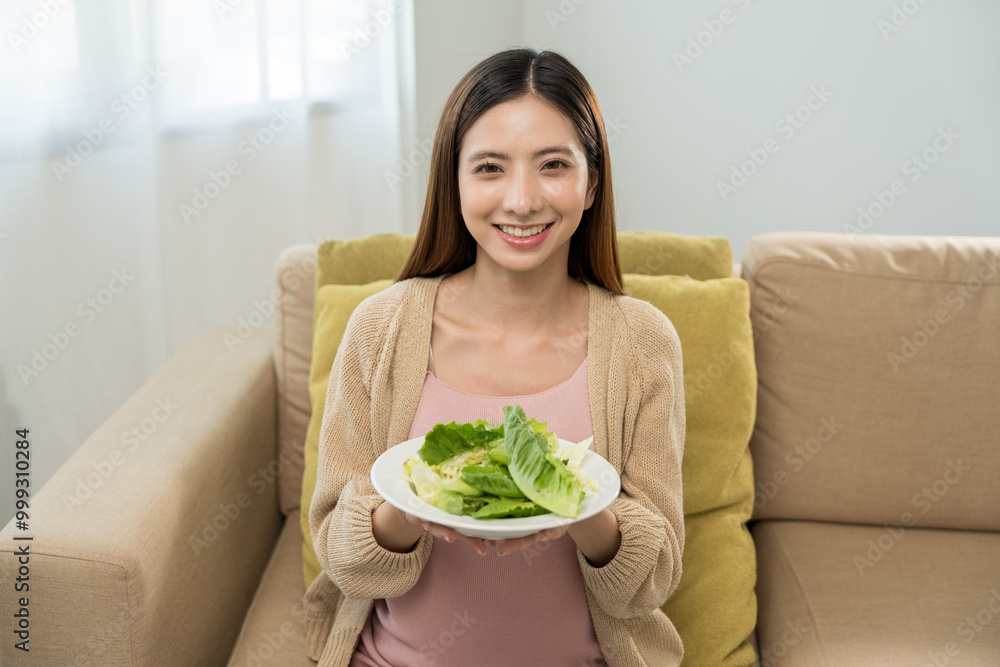 Happy pregnant woman eating vegetable salad and smiling to camera, concept of healthy mother taking health care and nourish her fetal and waiting her childbirth. Happy pregnant woman eating vegetable salad and smiling to camera, concept of healthy mother taking health care and nourish her fetal and waiting her childbirth.