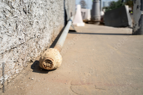 Photos A recently uprooted metal pole, adorned with a traffic sign, rests on the sidewa