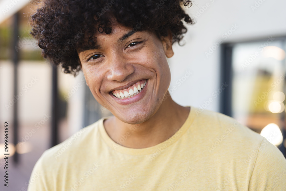 Smiling young man enjoying outdoor hangout with diverse friends, wearing yellow shirt, at home Smiling young man enjoying outdoor hangout with diverse friends, wearing yellow shirt, at home