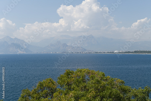 View of the blue sea from a hill with mountains in the background