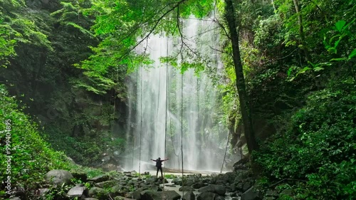 Slow motion video of a man discovering a hidden waterfall in Indonesia's tropical rainforest