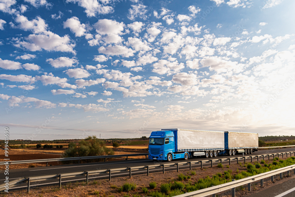 Truck with two trailers, also called Duo-trailer, driving on a highway under a cloudy sky. Truck with two trailers, also called Duo-trailer, driving on a highway under a cloudy sky.