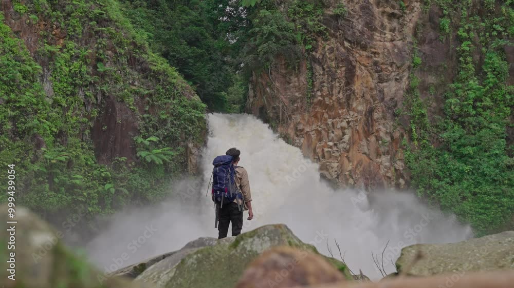 Slow motion video of a man discovering a hidden waterfall in Indonesia's tropical rainforest Slow motion video of a man discovering a hidden waterfall in Indonesia's tropical rainforest