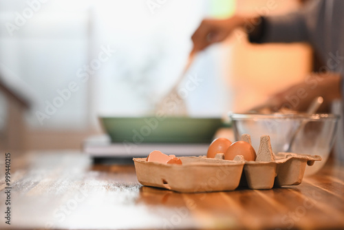 Close up shot of organic eggs in a carton tray on a wooden kitchen counter photo