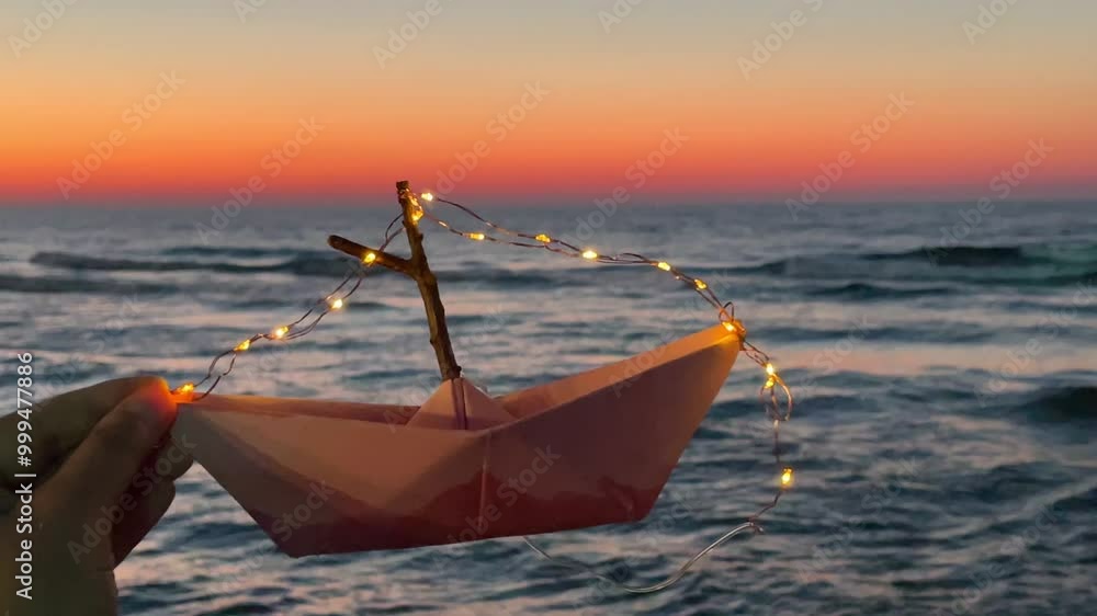 paper boat with lantern lights in sunset