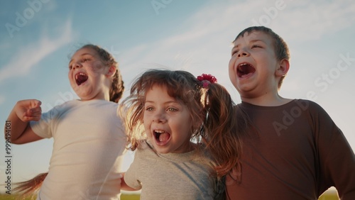 Billede på lærred group of kids team hugging a jumping and rejoicing outdoors