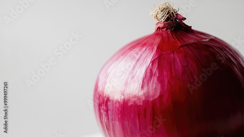 Bright red onion showcasing smooth layers and a glossy surface set against a white backdrop photo