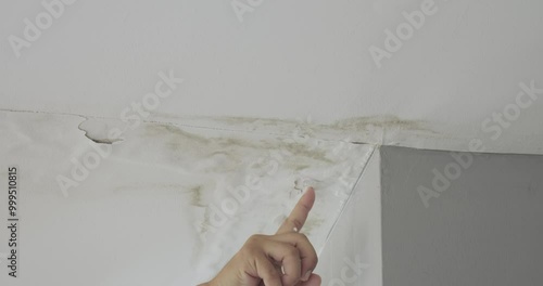 Male finger is peeling paint on ceiling, Office building or house problem for house service. High definition shot at 4K, 50 fps video footage.
