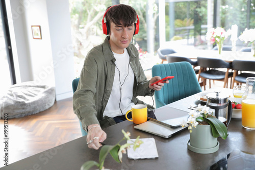 Man using smart phone and wearing headphones photo