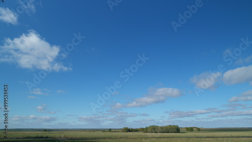 Countryside. Rural autumn landscape with a field. Blue sky in the background. Timelapse.