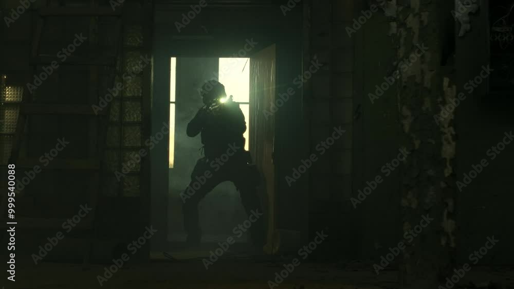 SWAT operator in all black gear and an assault rifle breaching a door in an abandoned warehouse SWAT operator in all black gear and an assault rifle breaching a door in an abandoned warehouse