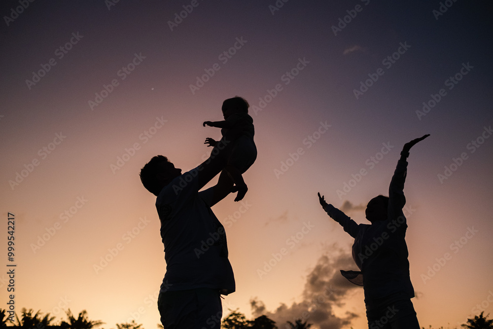 Silhouettes of Parents and Child at Sunset. Silhouettes of Parents and Child at Sunset.