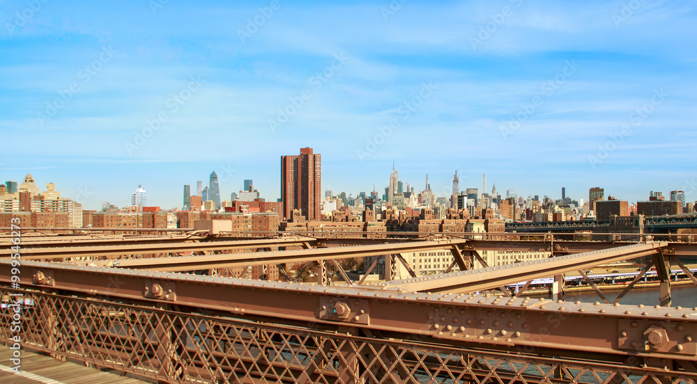 Fototapeta premium Rascacielos de Nueva York mirando al norte desde el puente de Brooklyn. Vista panorámica del skyline de la ciudad y sus rascacielos más emblemáticos desde el puente sobre el río Este. 2019.