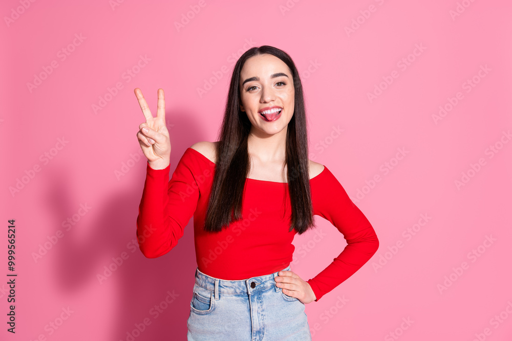 Portrait of pretty young woman show v-sign tongue red shirt isolated on pink color background Portrait of pretty young woman show v-sign tongue red shirt isolated on pink color background