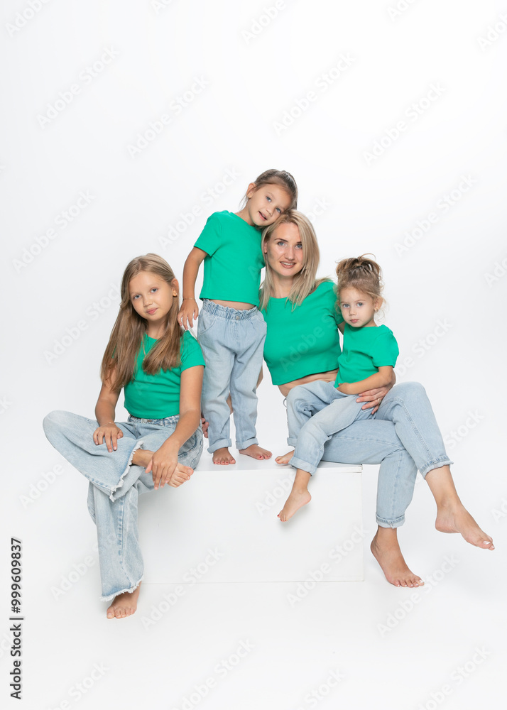 Front portrait of a modern family concept. Young mom with her daughters, posing in studio. Enjoy time together. Front portrait of a modern family concept. Young mom with her daughters, posing in studio. Enjoy time together.