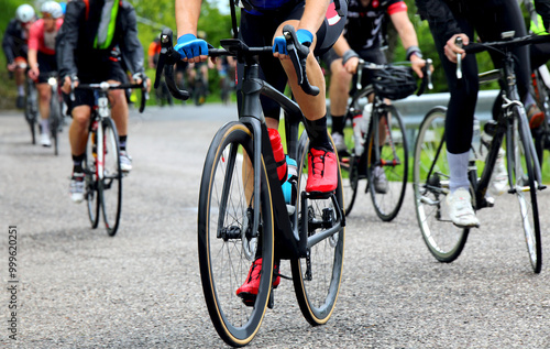 group of cyclists on a road focusing on the legs and bikes with cycling shoes