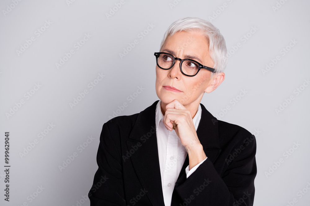 Photo portrait of lovely pensioner lady startup boss look minded empty space dressed formalwear specs isolated on gray color background Photo portrait of lovely pensioner lady startup boss look minded empty space dressed formalwear specs isolated on gray color background
