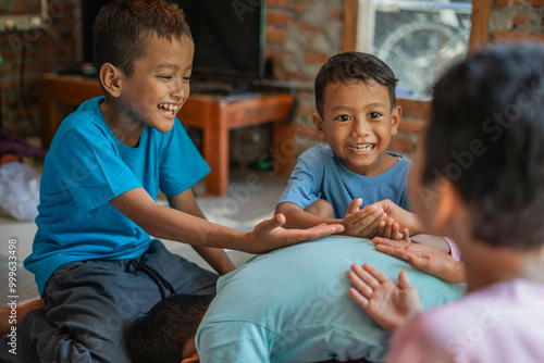 cheerful kids putting their hands over friend back while playing traditional games photo