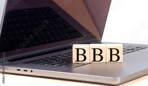 Business concept with wooden blocks displaying BBB on a laptop keyboard