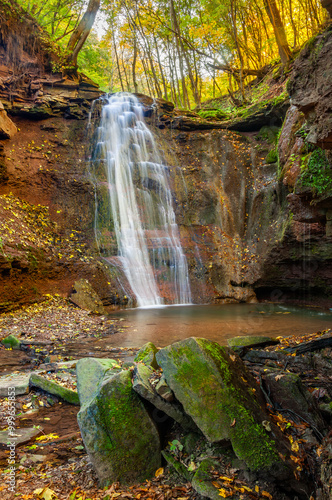 Picturesque waterfall on a mountain stream in the autumn forest One of the waterfalls of the cascade of Rusiliv waterfalls. Rusyliv, Ternopil Region, Ukraine photo