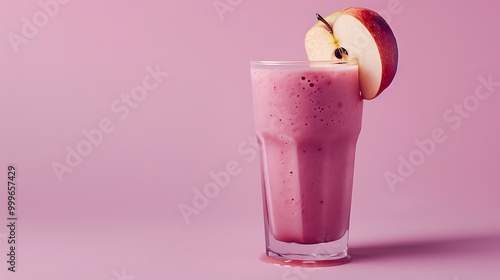 Warm fruit smoothie with a piece of apple on a mauve backdrop