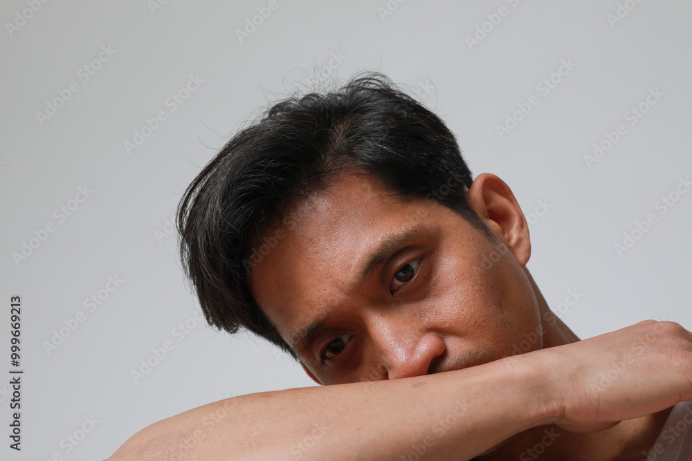 Close-up portrait of serious asian man posing over white background looking at the camera. Close-up portrait of serious asian man posing over white background looking at the camera.