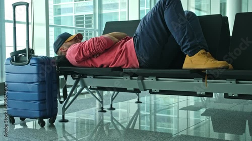 Tired Passenger Experiencing Jet Lag Taking a Nap on Bench at Airport Terminal Waiting for Connecting Flight in Departure Hall Transfer Area 
