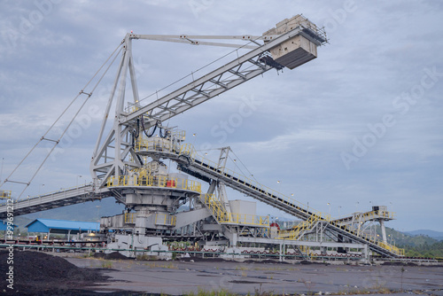 Industrial Conveyor Belt System. A large industrial conveyor belt system with a crane in a mining facility.