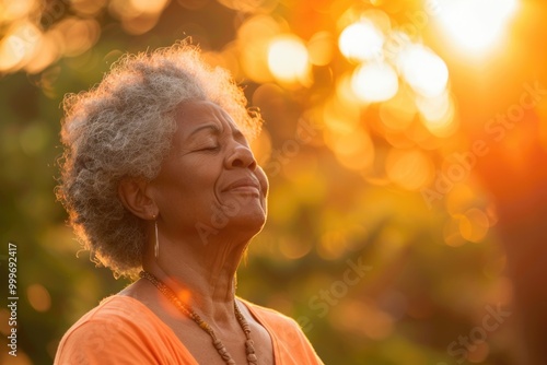 A woman with her eyes closed looks up at the sun, serene and peaceful